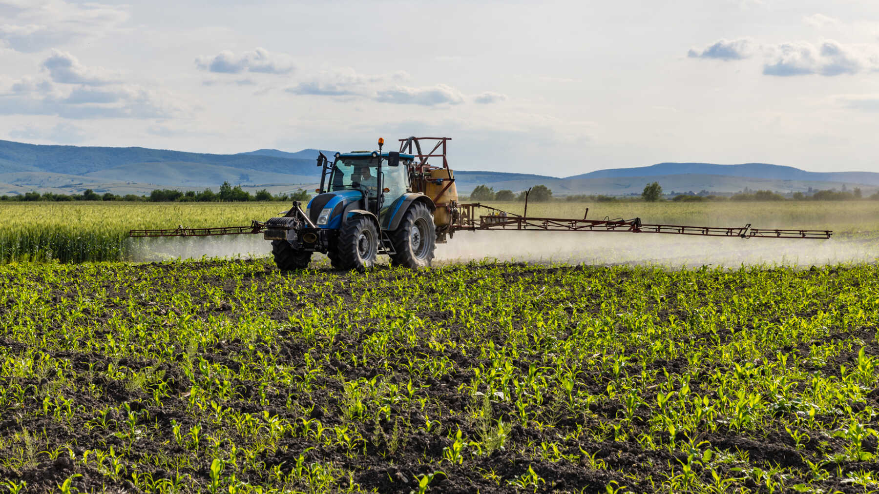 Trattore in campo che effettua un trattamento