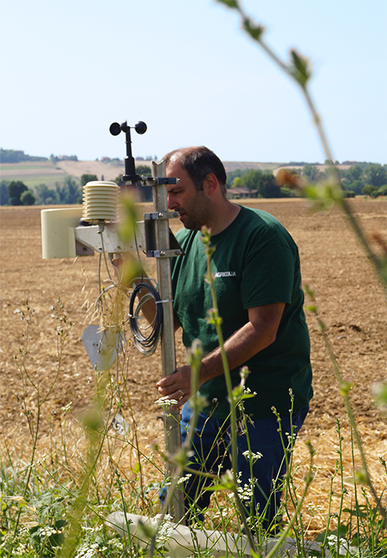 tecnico Agricolus in campo che controlla una stazione agrometeo