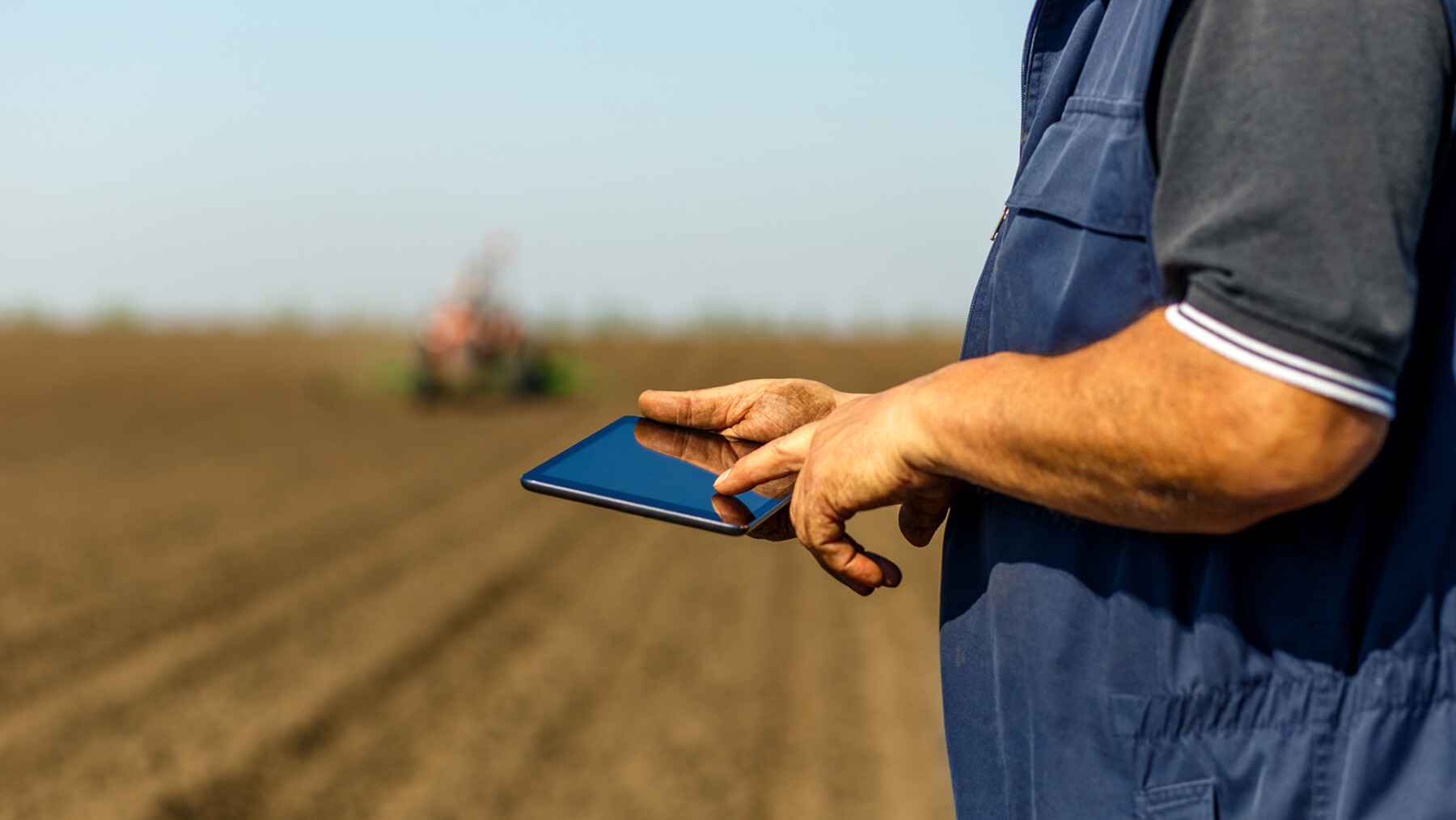 agricoltore in campo che consulta un tablet con i sistemi di supporto alle decisioni